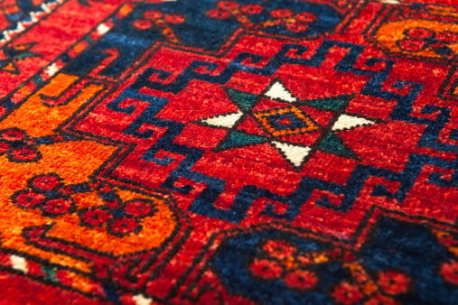 A detail showing the central motif on a brilliant red Middle Eastern Rug.