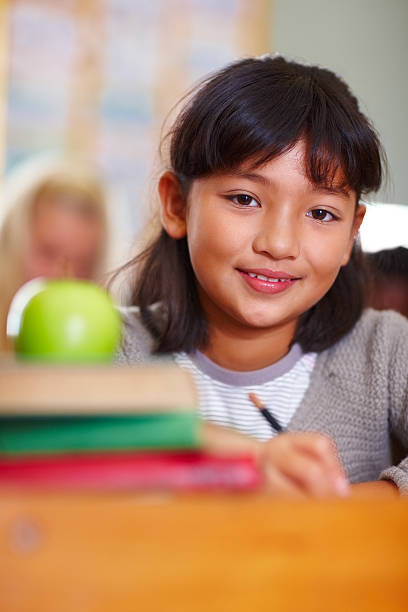 istock Schoolgirl with a green apple kept on her books 176123333