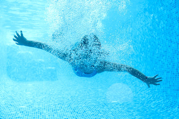 istock Young girl diving in a swimming pool. 176123680