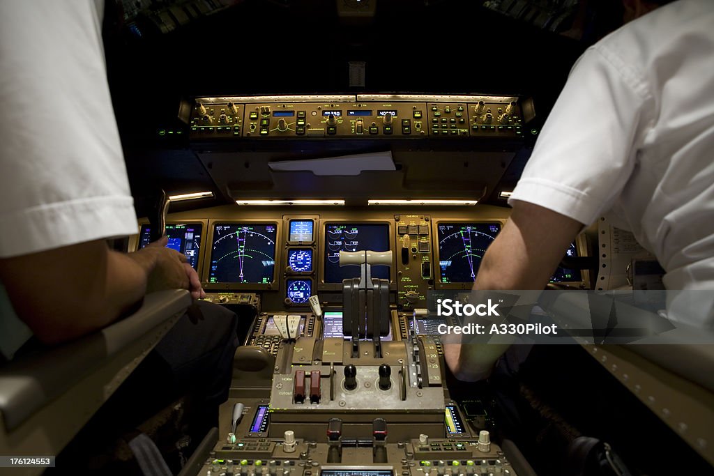 Airline Cockpit at Night The muted lights of an airline cockpit at night.The muted lights of an airline cockpit at night.AVIATION Throttle Stock Photo