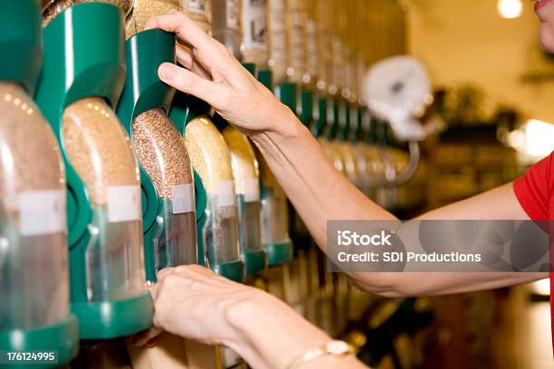 Mujer Adulta Putting En Los Gránulos En Una Bolsa De Supermercado Foto de stock y más banco de imágenes de Comprar