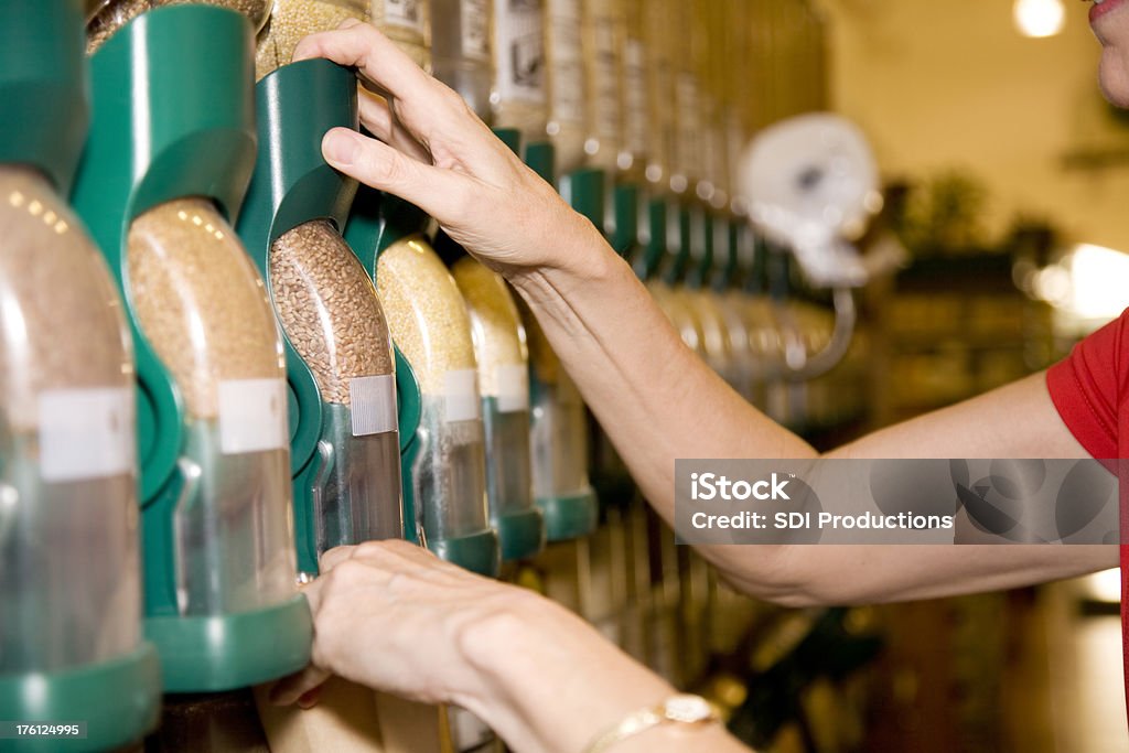 Adulto mulher colocando os grãos no saco na Loja de mercearia - Royalty-free Cereal Foto de stock