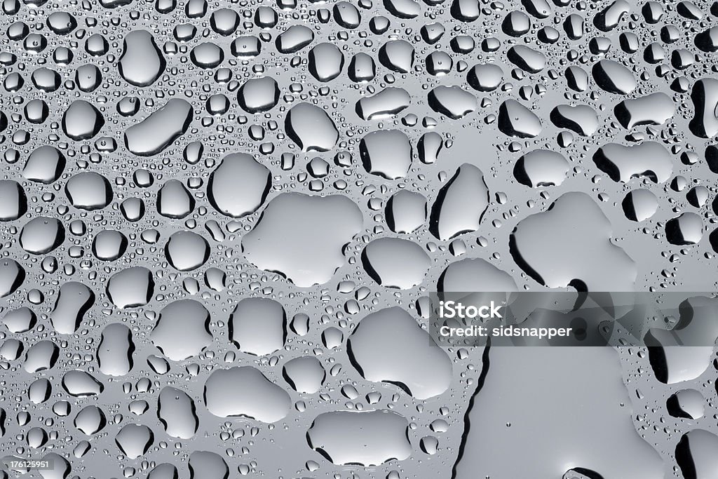 Irregular sized drops of condensation Irregular sized and shaped droplets of condensation on a grey surface. Backgrounds Stock Photo