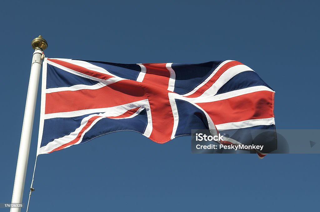 Union Jack flottant sur mât du drapeau dans ciel bleu - Photo de Drapeau du Royaume-Uni libre de droits