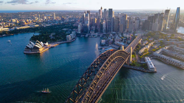 drohnenaufnahme von sydney city und sydney harbour mit blick auf die sydney harbour bridge, nsw am späten nachmittag - sydney harbor sydney australia australia sydney harbor bridge stock-fotos und bilder