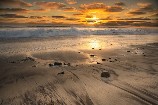 A beautiful landscape of a tranquil beach scene during the golden hour of sunset