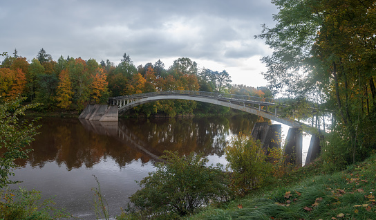 Arched bridge over Ogre river in autumn day Ogre, Latvia .