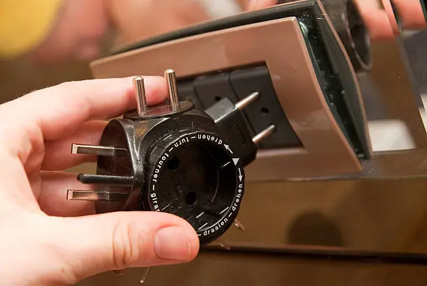 human hand is using an adapter for power line