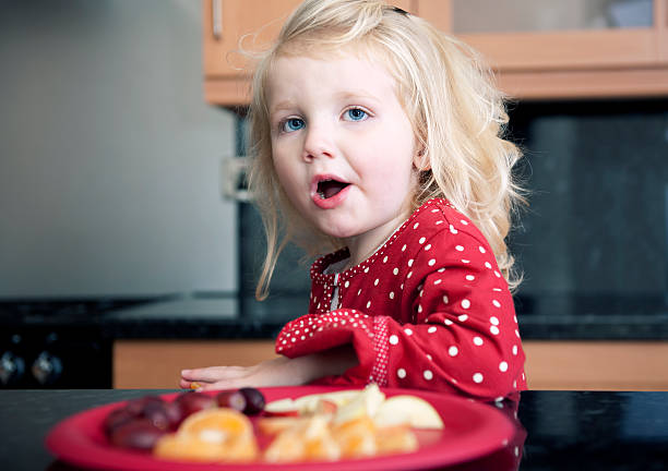 istock little girl having fruit snack 176130254