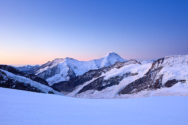 Mountain peaks at dawn from Jungfraujoch in Switzerland High in the mountains of the Swiss Alps at dawn. The high peak of the Aletschhorn just right of the center of the photograph. jungfrau stock pictures, royalty-free photos & images