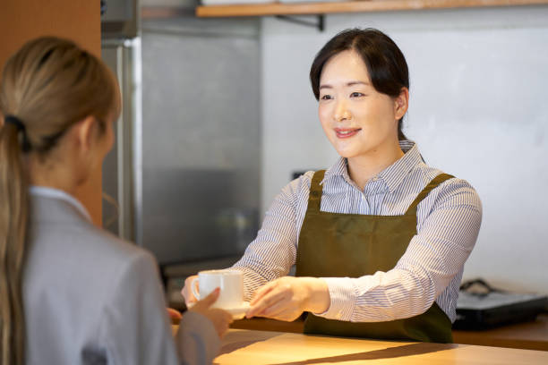 istock Cafe worker passing coffee over the counter 1761315132