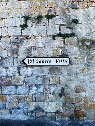 Street sign on an old stone wall