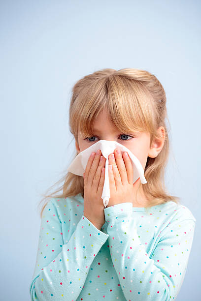 istock Young girl with tissue blowing her nose with white wall 176133579