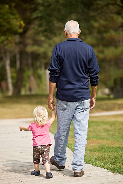 istock Grandfather and Granddaughter walking holding hands 176135287