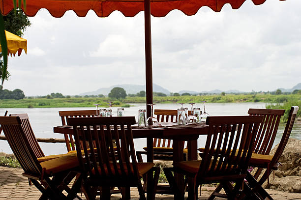 A dining set outdoors with umbrella overlooking the water.