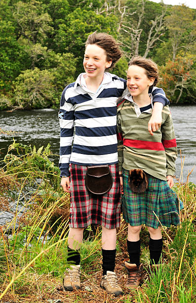 Scottish Brothers Two young Scottish brothers wearing kilts on a river bank. Smiling and looking to the left. kilt stock pictures, royalty-free photos & images