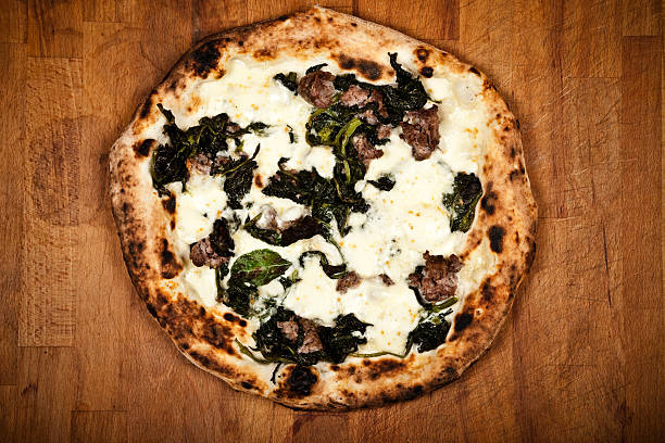 Gourmet veggie pizza with arugula and feta cheese on a textured surface
