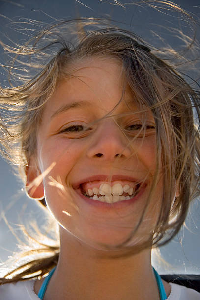 istock Laughing girl with wind blowing hair backlit 176143159