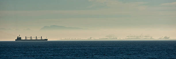 istock Bulk Freighter cruises past harbor in fog 176143188