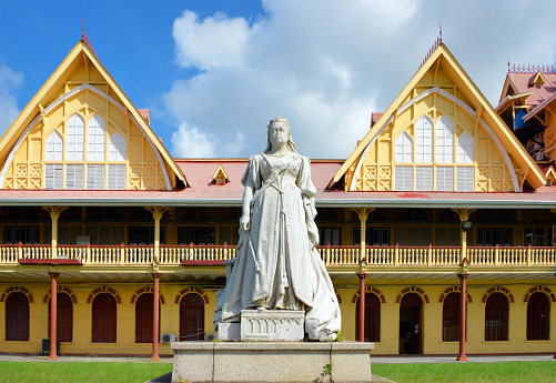 Georgetown, Demerara-Mahaica, Guyana: statue of Queen Victoria in front of the High Court - commissioned in 1887 to mark the Golden Jubilee, this statue was unveiled in 1894, sculptor Henry Richard Hope-Pinker, damaged by a bomb in 1954, in an act of anti-colonial protest, the nose is still missing - The Supreme Court Of Judicature, The High Court - The compound, originally called The Victoria Law Courts opened in 1887, on Queen Victoria’s Diamond Jubilee, by British Governor Sir Henry Irving. The “L” shaped building was designed by Baron Hora Siccama, the Colonial Engineer and Cesar Castellani, then Assistant Architect of the Public Works Department.