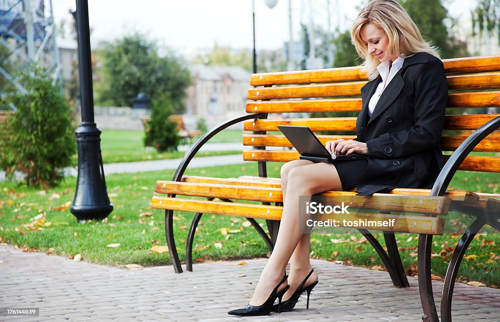 Trabajando en una computadora portátil en el parque - Foto de stock de Adulto libre de derechos