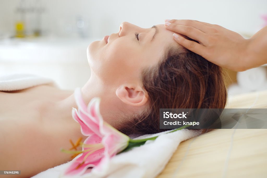 Mujer en el spa en una mesa de masajes - Foto de stock de 25-29 años libre de derechos