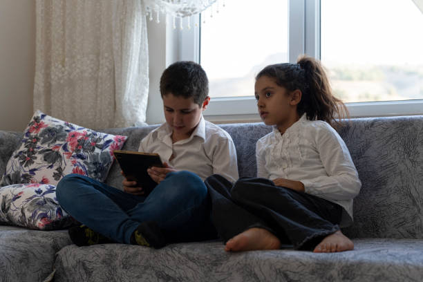 istock Brother and sister playing games with tablet. 1761471447