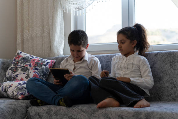 istock Brother and sister playing games with tablet. 1761474808
