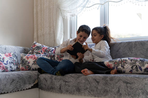 istock Brother and sister playing games with tablet. 1761480172