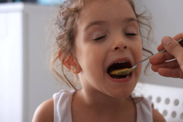 istock Mother feeding little girl with spoon 1761504592