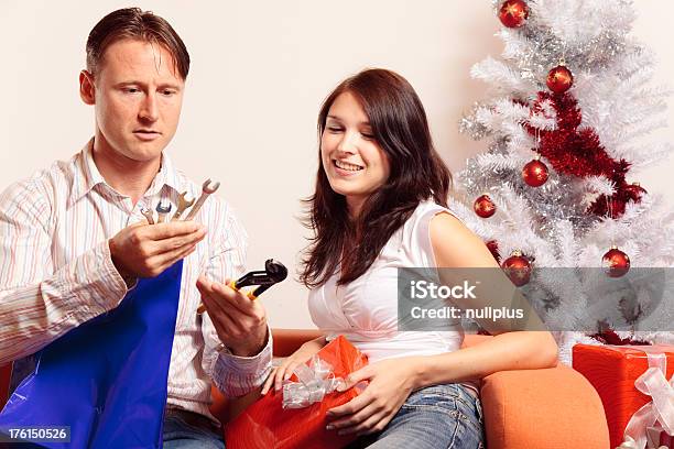 Young Couple Exchanging Christmas Gifts Stock Photo - Download Image Now - Gift, Mistake, Adult