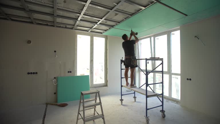 Man assembles profile metal frame for plasterboard ceilings