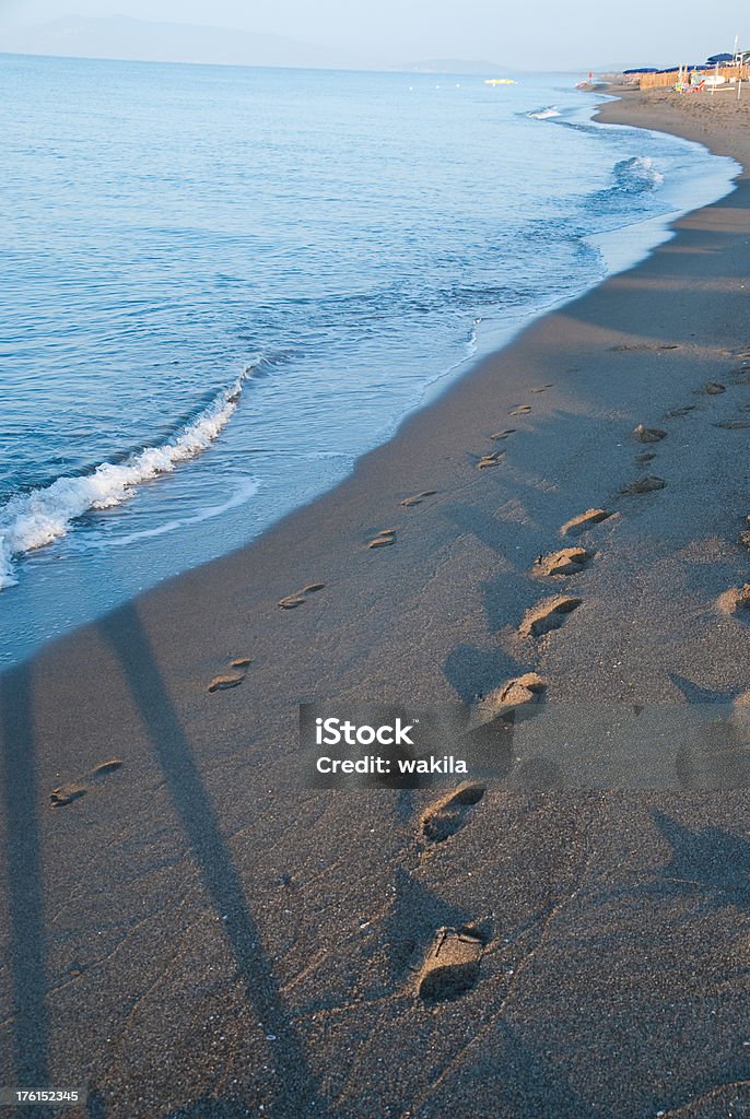footsteps at beach in morning sun footsteps in the sand at the beach Backgrounds Stock Photo