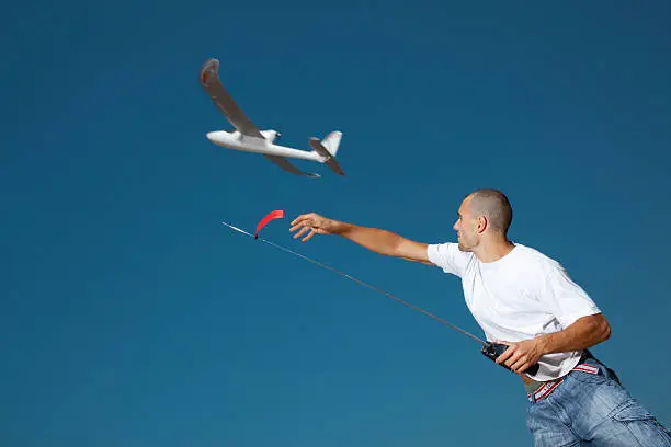 Boy throwing airplane model, pronounced motion blur.