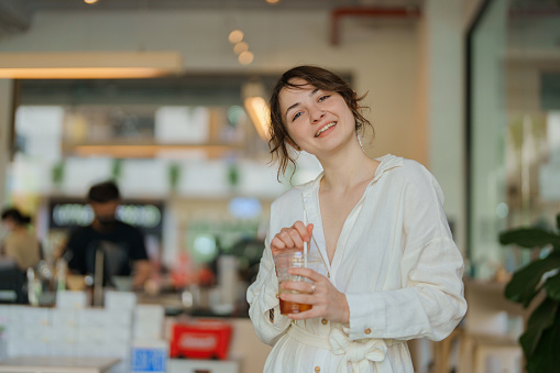 Portrait of cheerful  woman drinking coffee in cafe