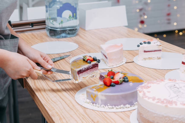 istock Cutting a chocolate mousse cake on the table. Preparation of mousse cakes at a culinary master class. Cooking at home, homemade food 1761589632