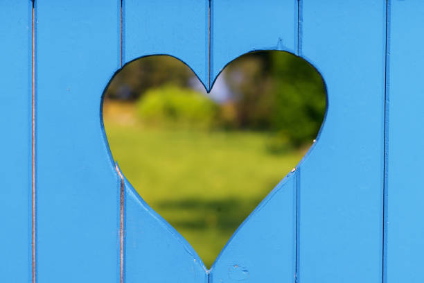 look through a heart shaped hole at a garden gate with focus on the foreground