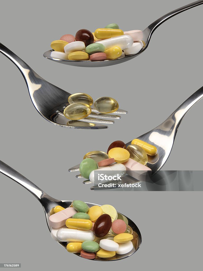 Spoon and fork of health Colorful pills on the spoon and fork isolated over grey with clipping path______________Please see some similar pictures from my portfolio______________ Addiction Stock Photo