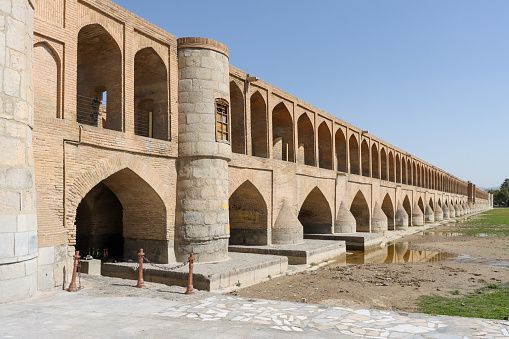 Isfahan, Iran - July 31 2023: Si-o-se-pol Bridge. The famous two-storey stone bridge with 33 arches over the Zayandeh River in Isfahan.