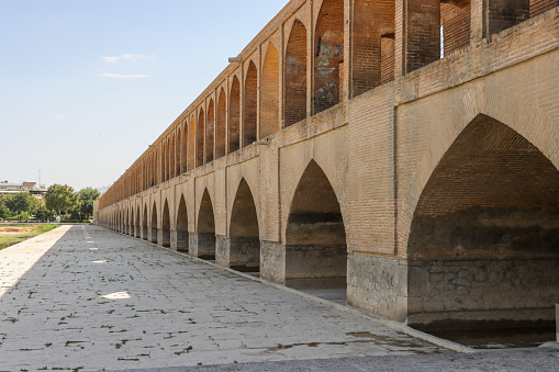 Isfahan, Iran - July 31 2023: Si-o-se-pol Bridge. The famous two-storey stone bridge with 33 arches over the Zayandeh River in Isfahan
