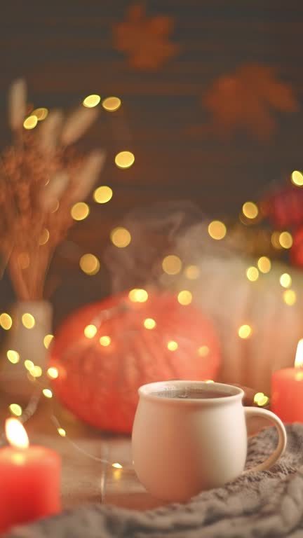 Autumn cozy composition. Tea in a mug, pumpkins and candles