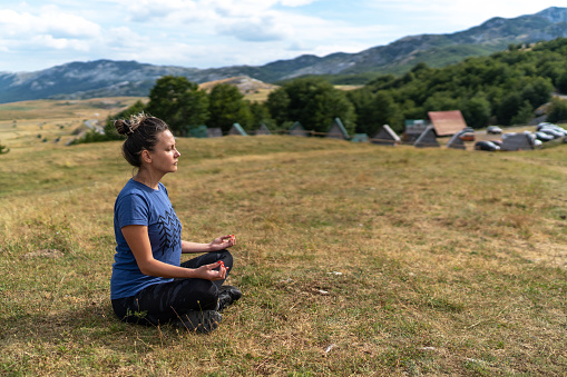 Young woman is meditating in mountains