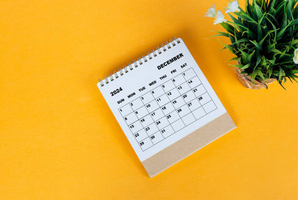 istock December 2024 desk calendar on yellow background. Directly above. Flat lay. 1761644669