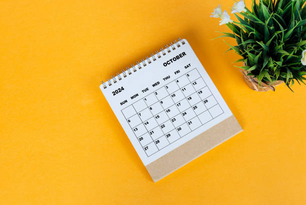 istock October 2024 desk calendar on yellow background. Directly above. Flat lay. 1761645388