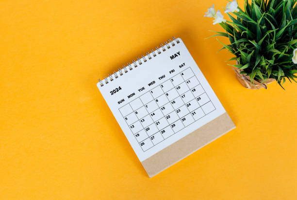 istock May 2024 desk calendar on yellow background. Directly above. Flat lay. 1761645426