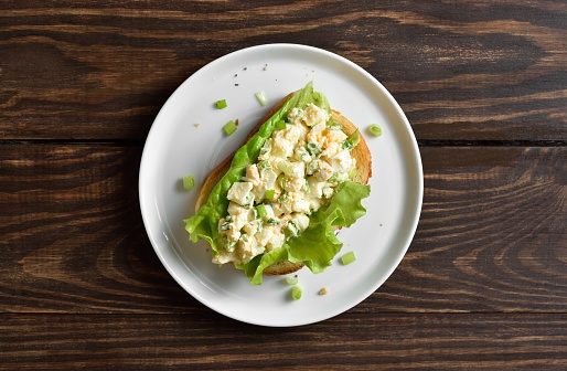 Egg salad sandwich on wooden background. Top view, flat lay
