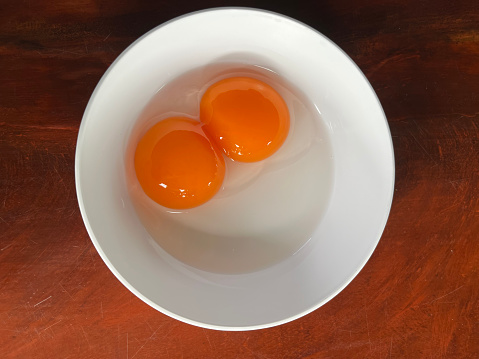 Double yolked egg from ducks in a white cup