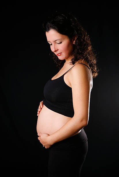 Pregnancy "5 months pregnant woman looking at her belly.For more of my similar images, please follow the banner link below:" 3 months pregnant belly stock pictures, royalty-free photos & images