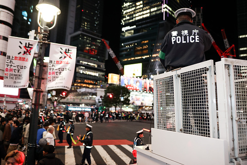 Police officers control pedestrian traffic as people cross the street during the Shibuya Halloween event on October 28, 2023 in Tokyo, Japan. It was the first time after four years that the festival was held due to the COVID-19 pandemic.