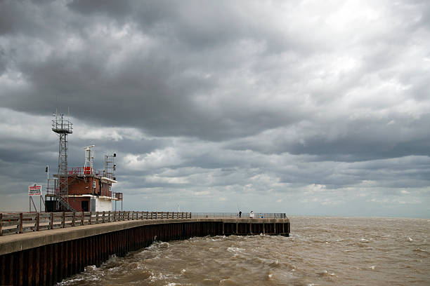 Gorleston Pier at the mouth of the River Yare, near Great Yarmouth in Norfolk. Choppy sea with threatening rain on a dull day.